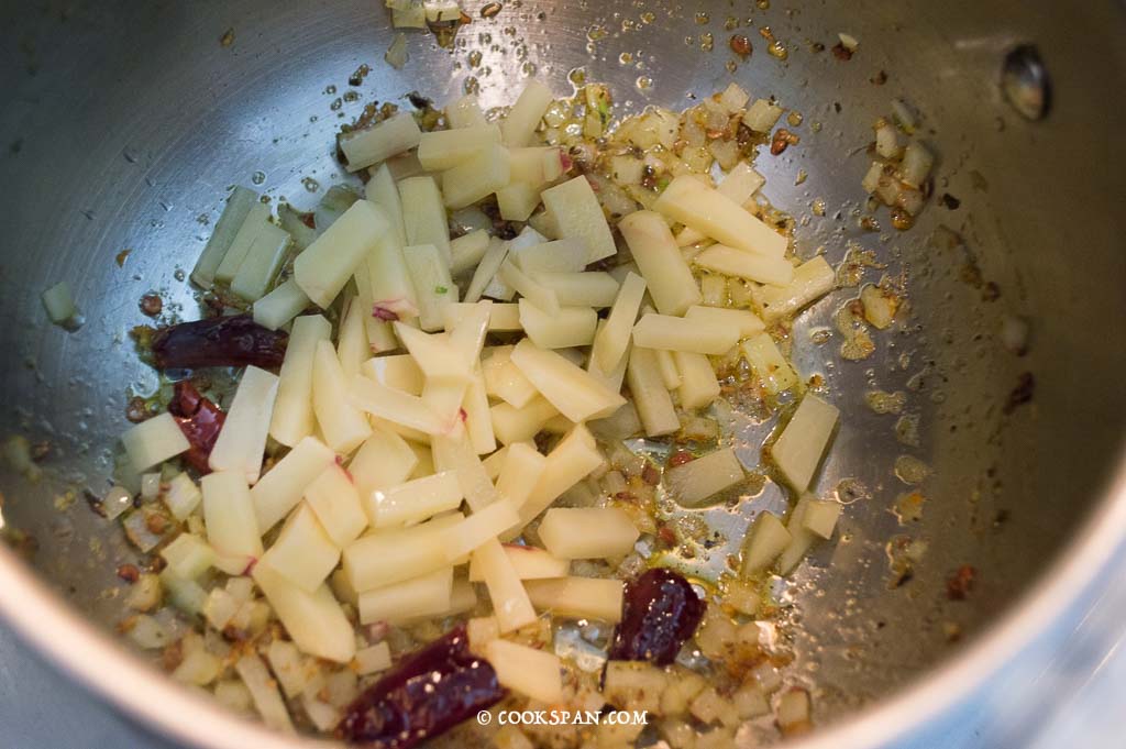 Adding the chopped potatoes to the Kadhi Gravy