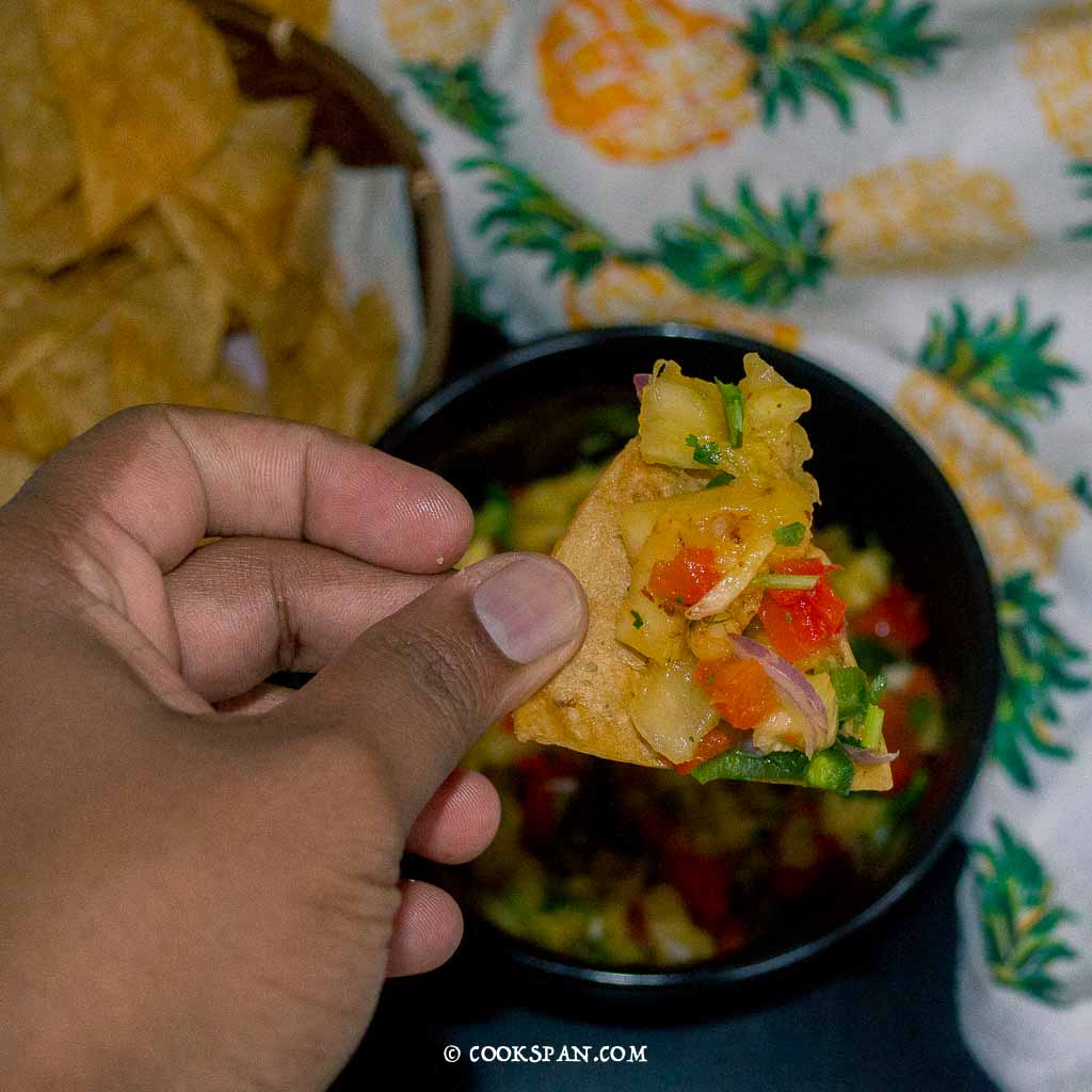 Tortilla chips with a generous bite of salsa